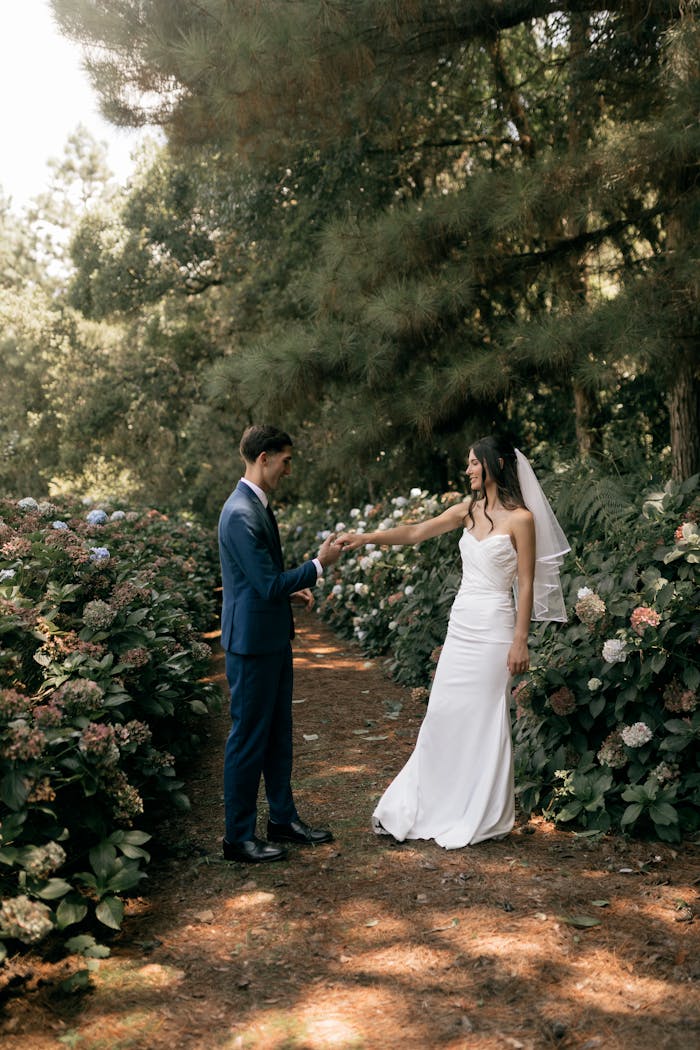 Bride and groom share a moment in a beautiful garden during their outdoor wedding ceremony.